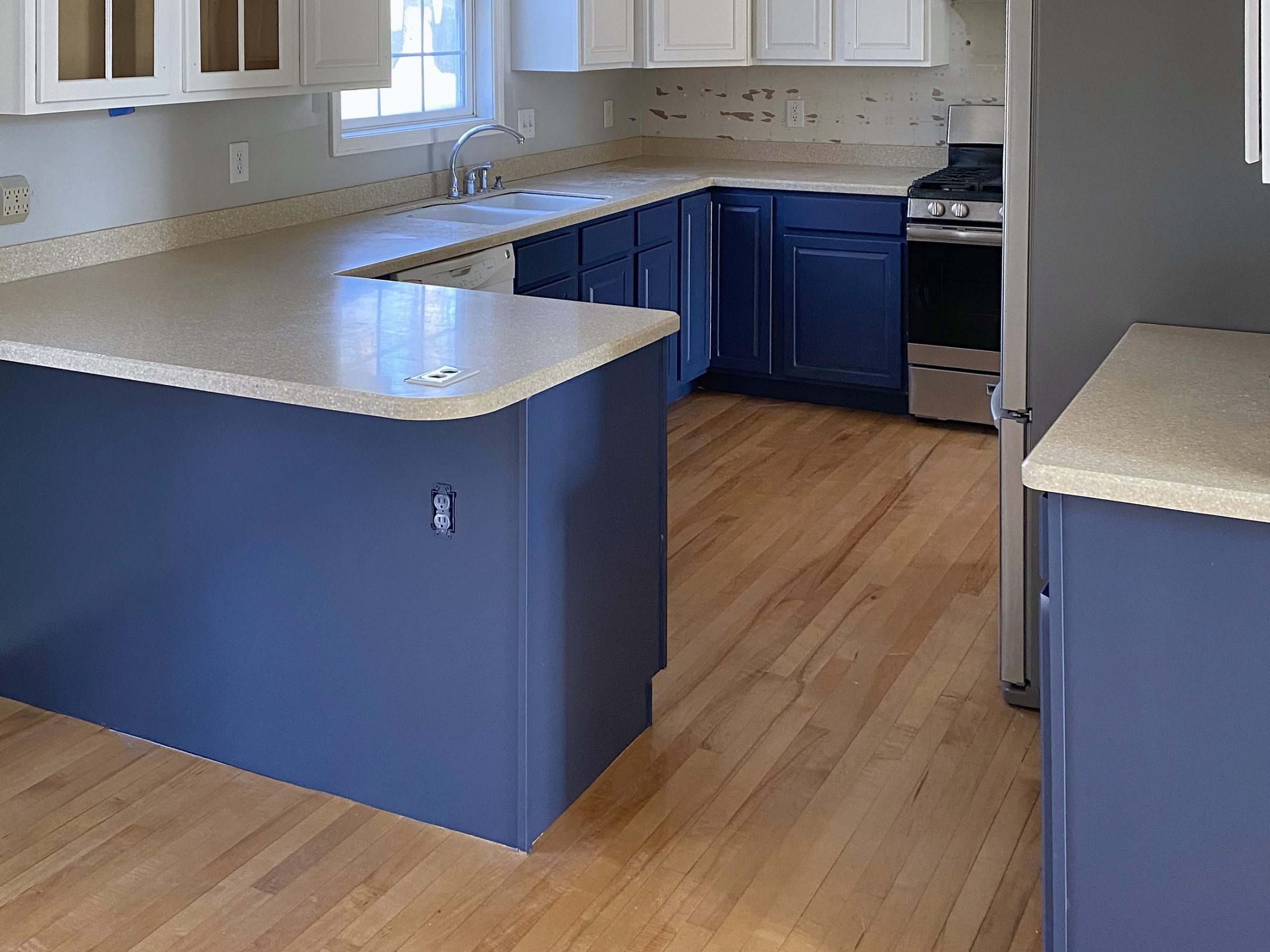Kitchen with a navy blue island and white counters