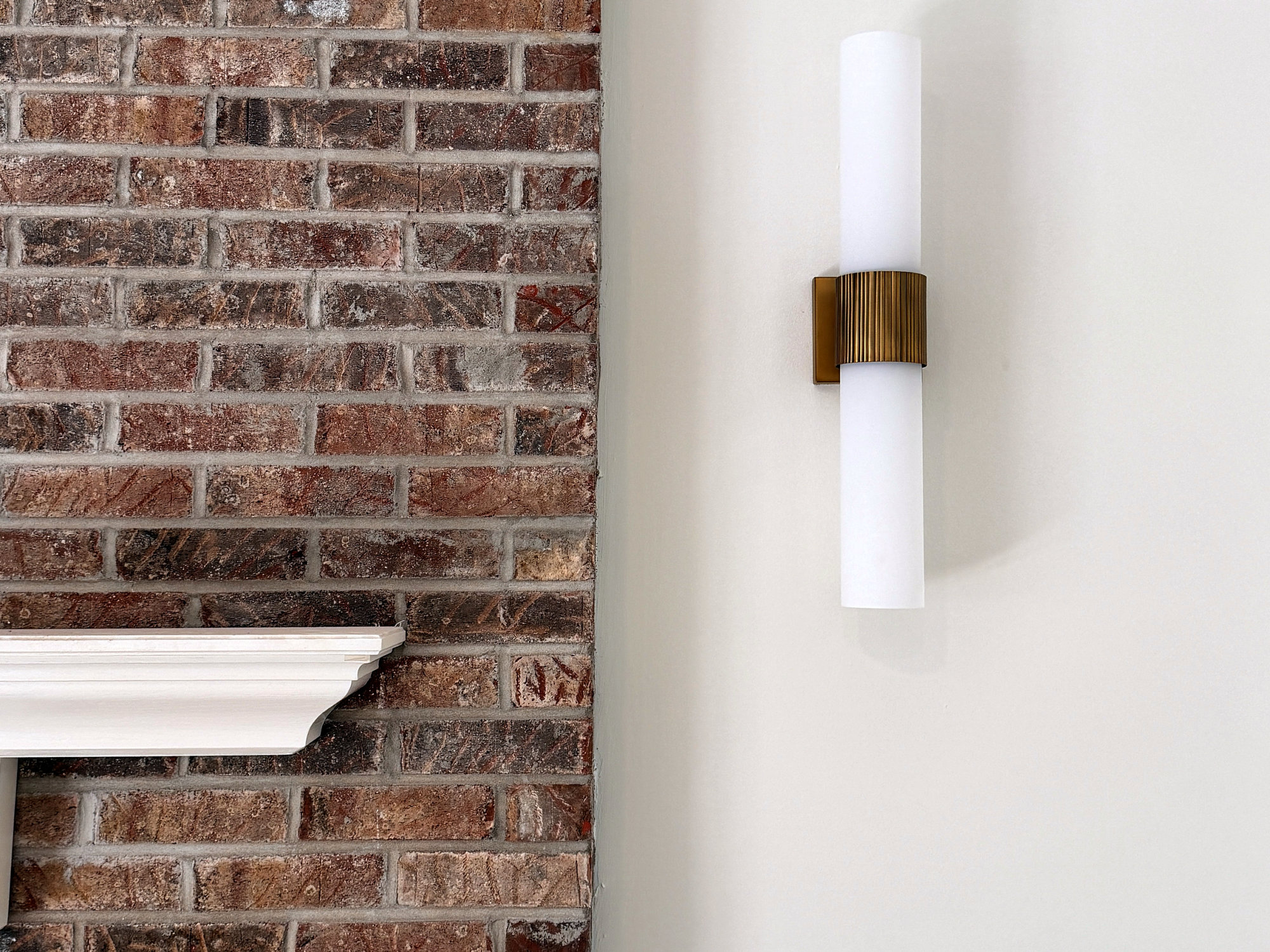 Brick fireplace edge with a wall sconce