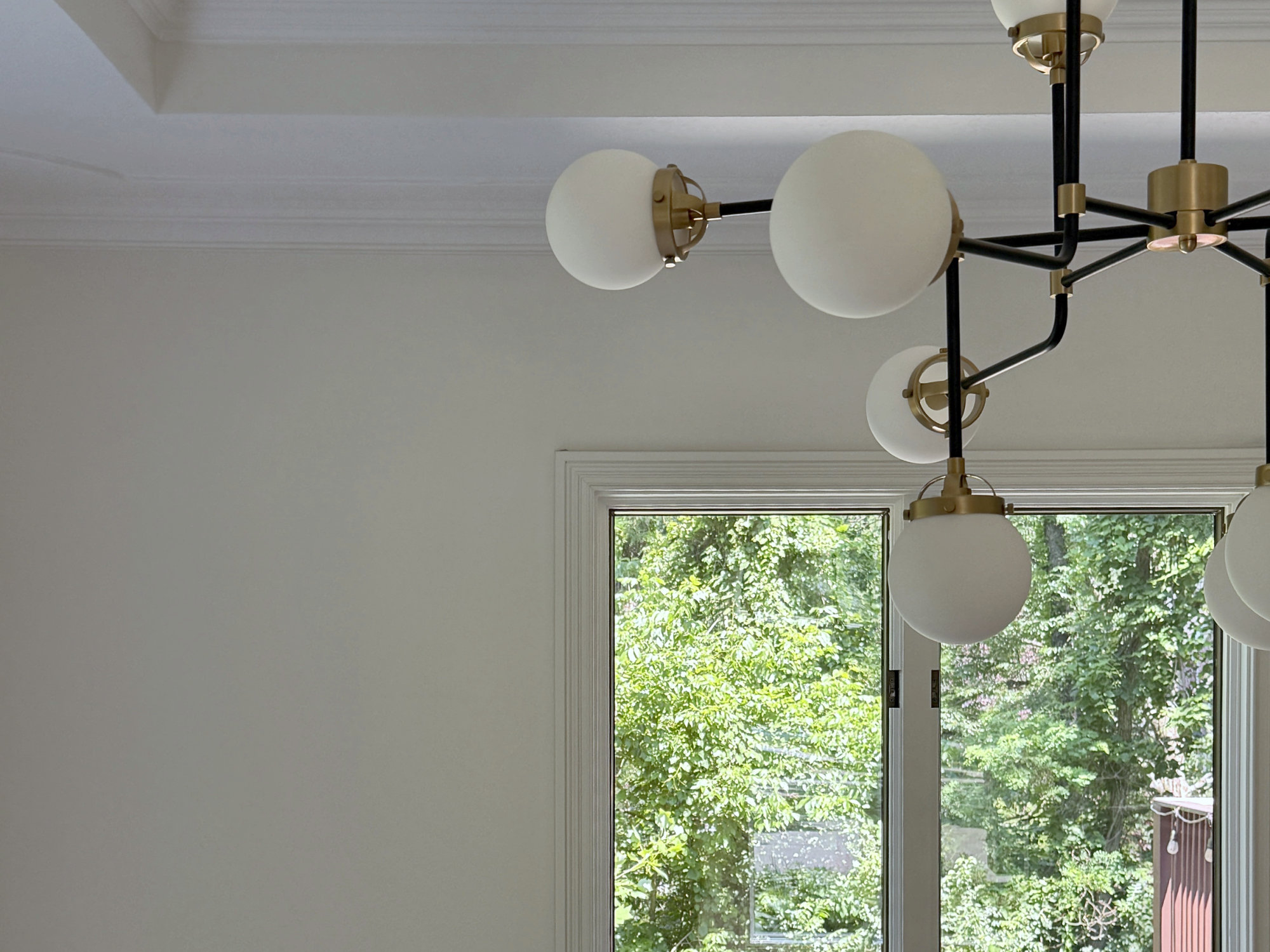Globe chandelier below a trimmed ceiling