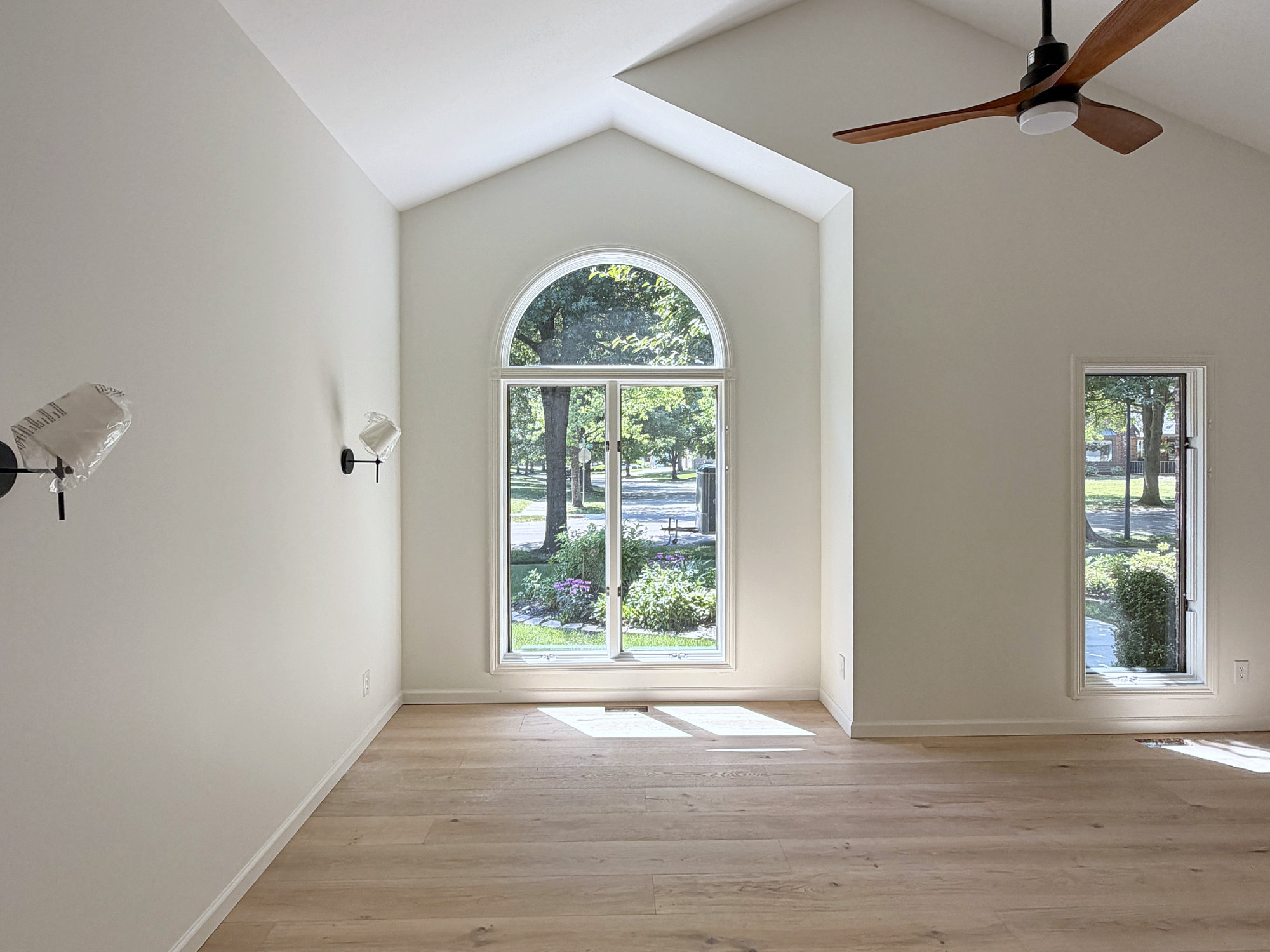 Vaulted great room with an arched window